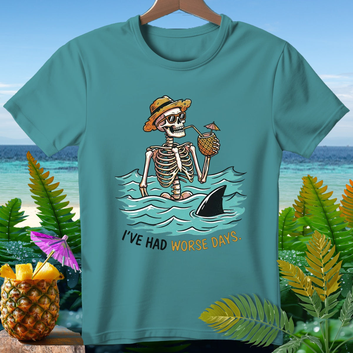 Skeleton in water with pineapple drink, shark fin, and text "I'VE HAD WORSE DAYS."