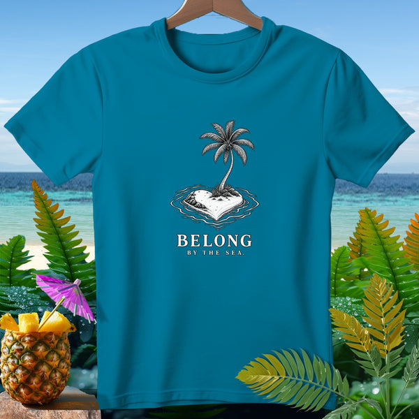 Teal t-shirt with "BELONG BY THE SEA." text and palm tree on a heart-shaped island.