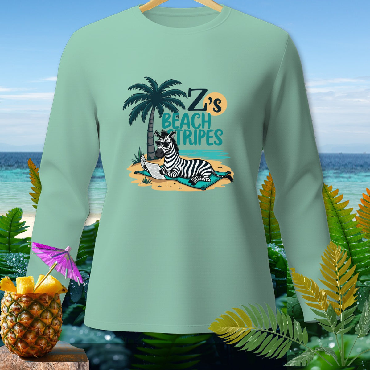 Mint long sleeve shirt with graphic of zebra reading on beach, "Z's Beach Tripes" text.