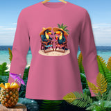 Pink long-sleeve shirt with two toucans wearing straw hats on a beach.