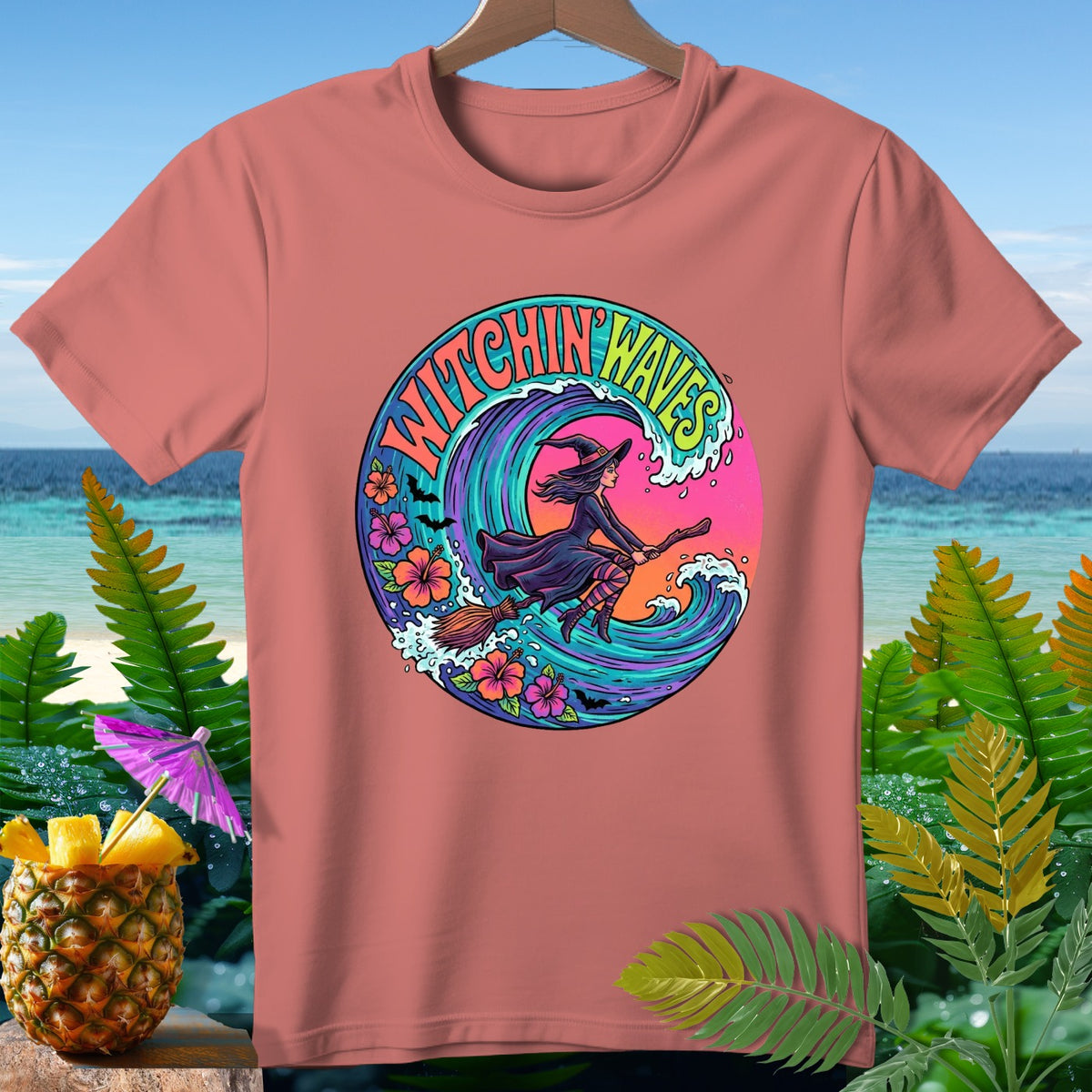 T-shirt with a circular graphic of a witch flying on a broom over a wave, text "Witchin' Waves".