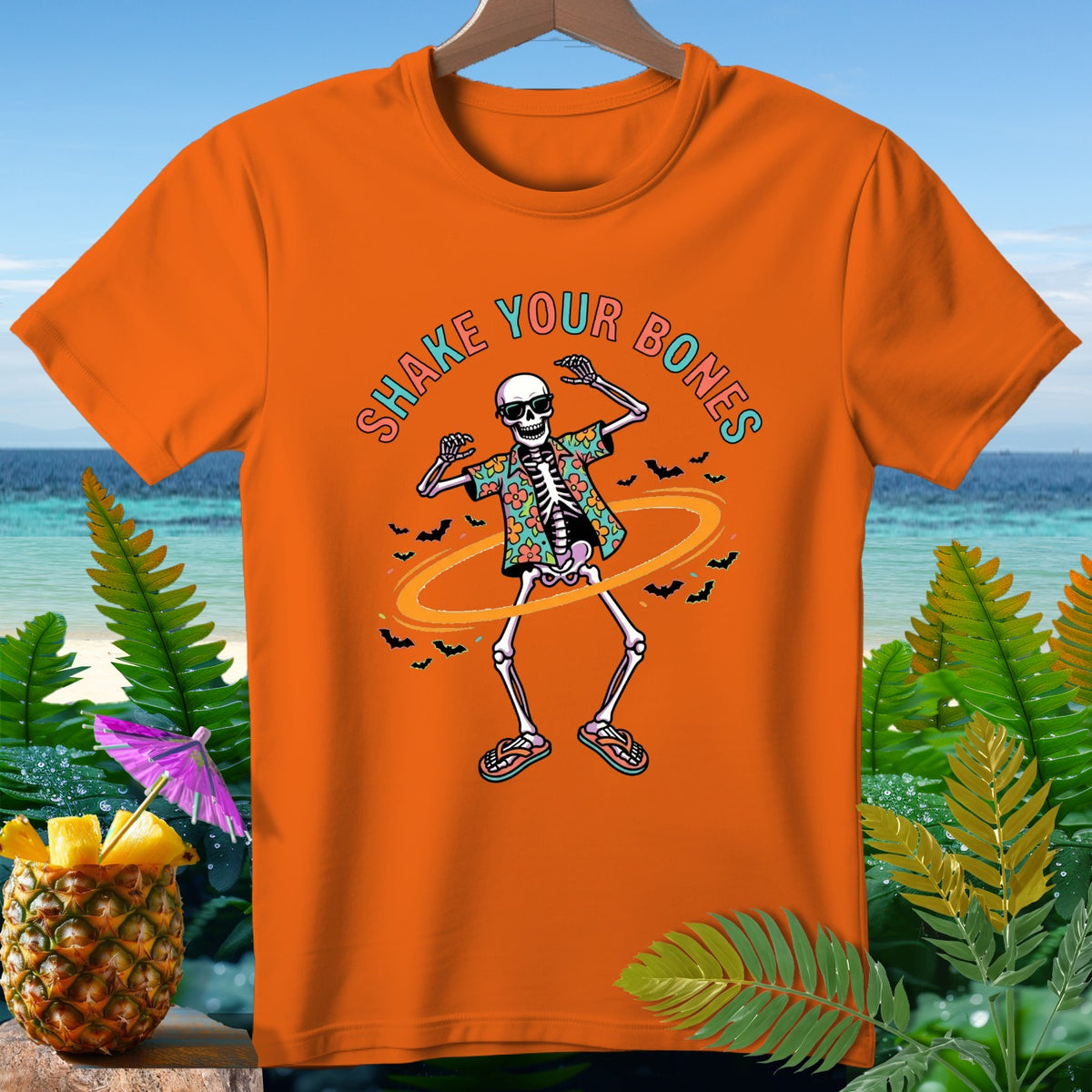 Orange t-shirt with skeleton dancing in Hawaiian shirt, text "SHAKE YOUR BONES".