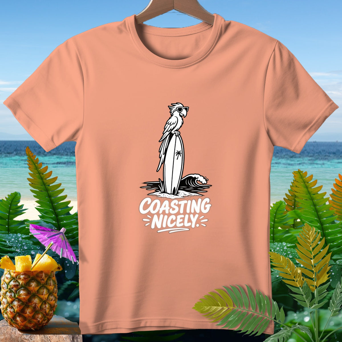 Peach t-shirt with a parrot on a surfboard design and text "COASTING NICELY".