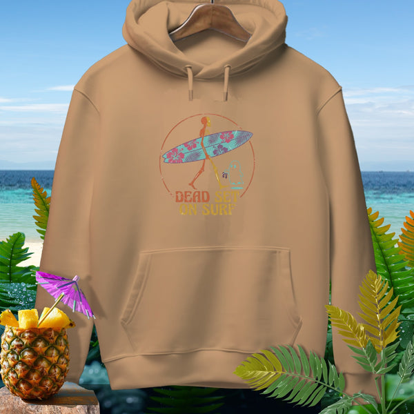 Tan hoodie with a circular graphic featuring a skeleton carrying a surfboard and the text "DEAD SET ON SURF."