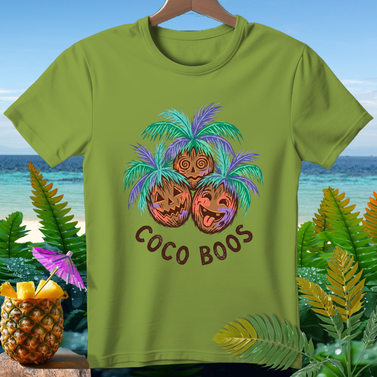 Green t-shirt with "Coco Boos" text and spooky coconut design.
