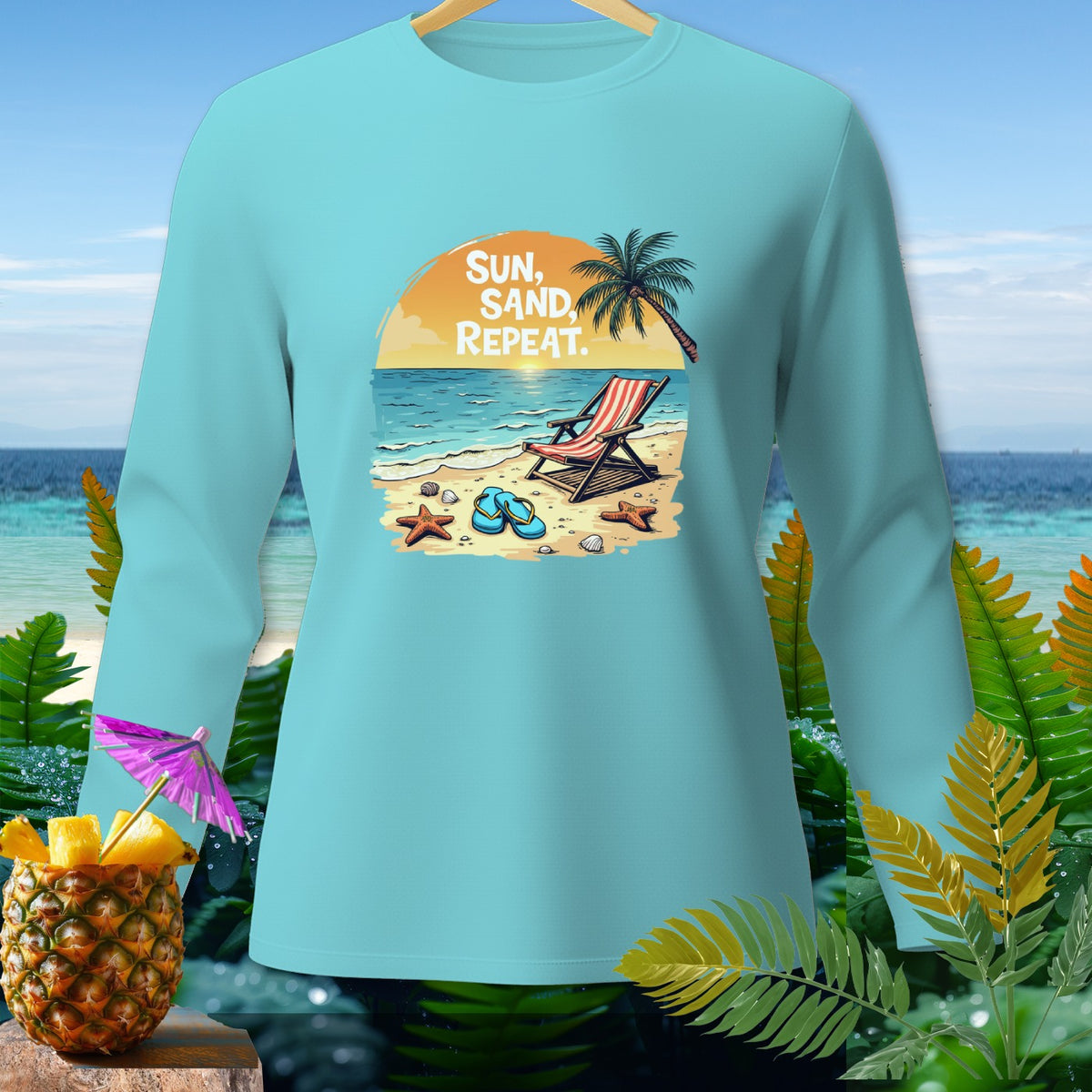 Light blue long-sleeve shirt with beach graphic and text "Sun, Sand, Repeat."