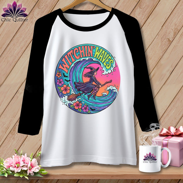 White t-shirt with black sleeves featuring a witch riding a broom over waves.