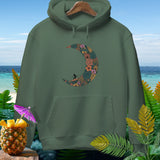 Green hoodie with floral crescent moon and surfer graphic, on beach background.