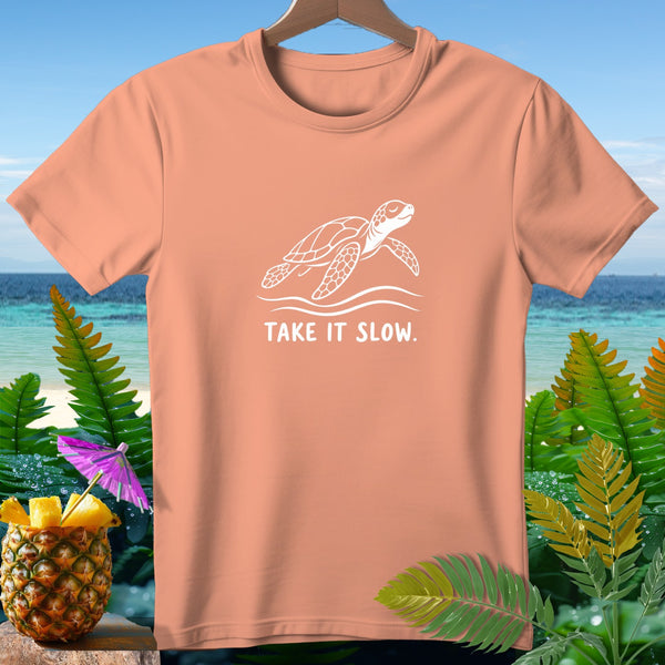 Coral t-shirt with white turtle graphic and "TAKE IT SLOW." text.