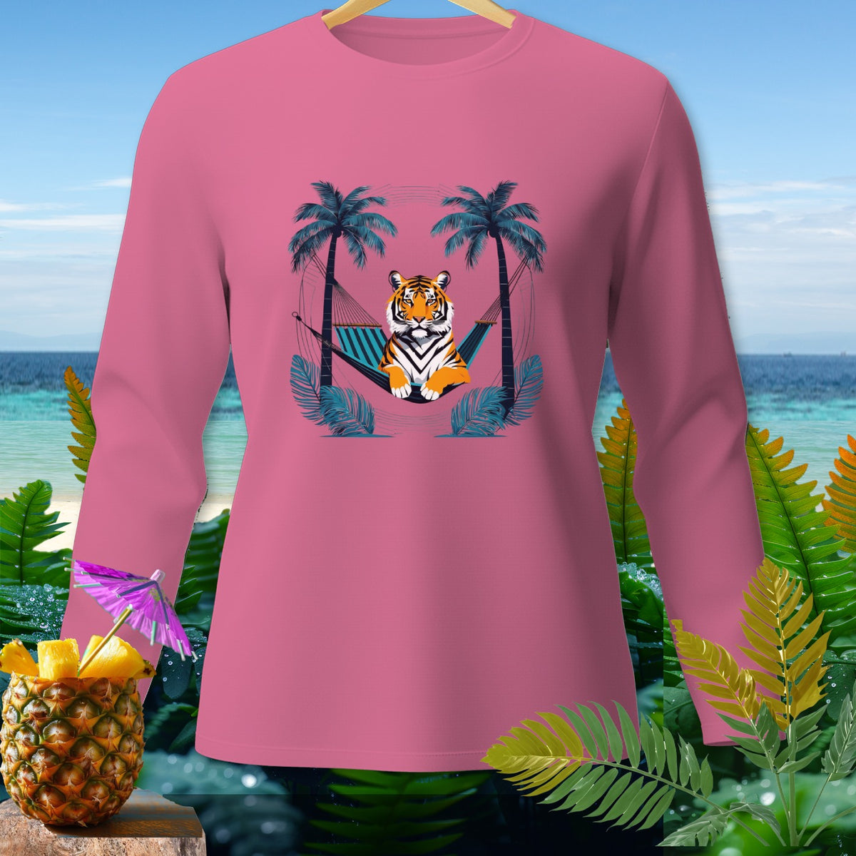 Pink long-sleeve shirt with a tiger relaxing in a hammock between palm trees.