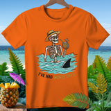 Orange t-shirt with a skeleton in a hat and sunglasses drinking from a pineapple, with a shark fin.