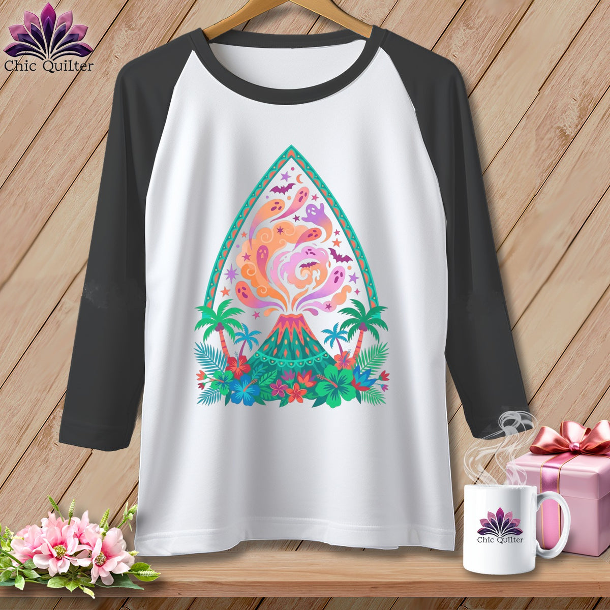 White raglan t-shirt with a colorful volcano, ghosts, bats, and tropical flowers graphic.
