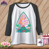 White raglan t-shirt with a colorful volcano, ghosts, bats, and tropical flowers graphic.