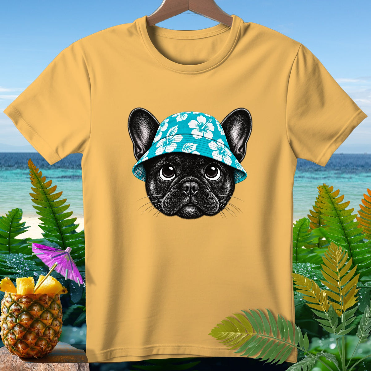 Yellow t-shirt with French bulldog wearing a floral bucket hat, beach background.