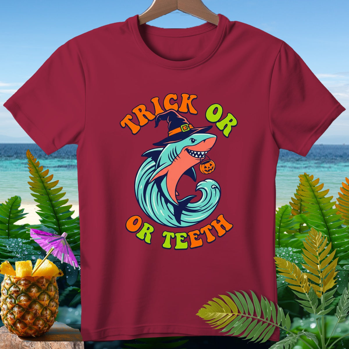 Burgundy t-shirt with Halloween shark design saying "Trick or Teeth."