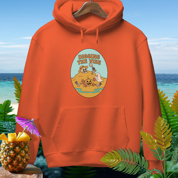 Orange hoodie with "Digging The Vibe" graphic featuring skeletons, pumpkin, and ghost.