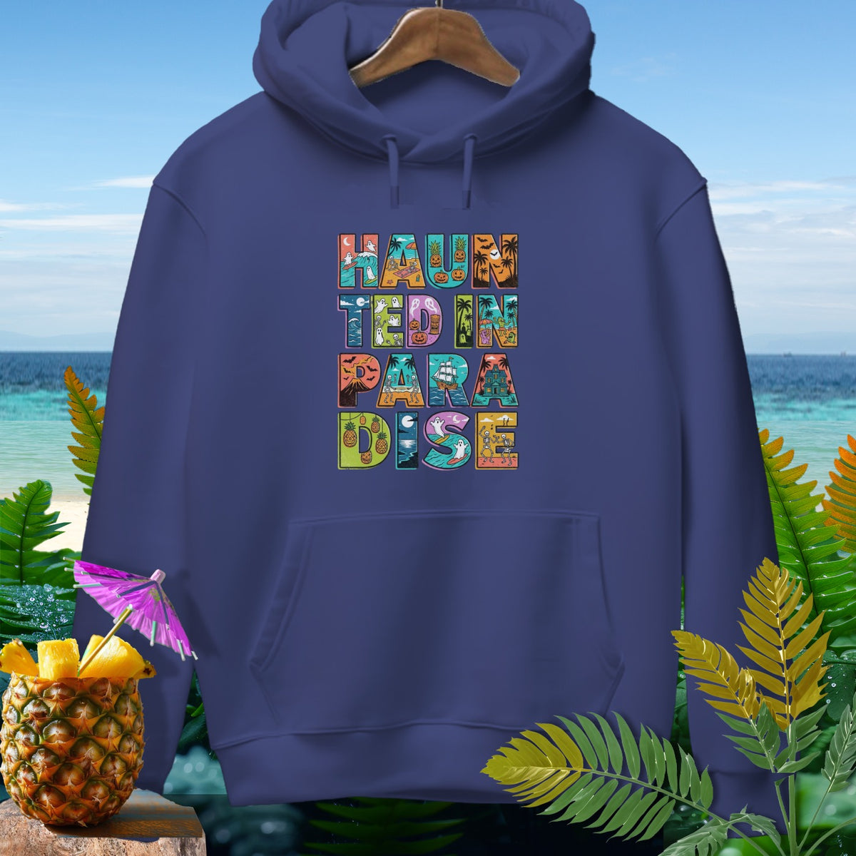 Dark purple hoodie with "Haunted in Paradise" text featuring Halloween and tropical island elements.
