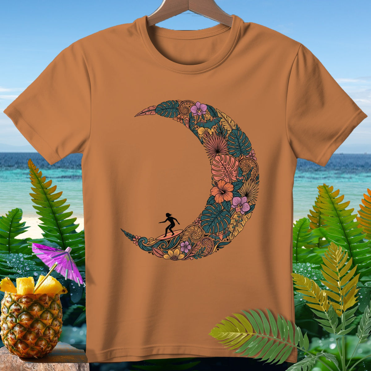 Orange t-shirt with crescent moon design filled with tropical leaves and flowers.