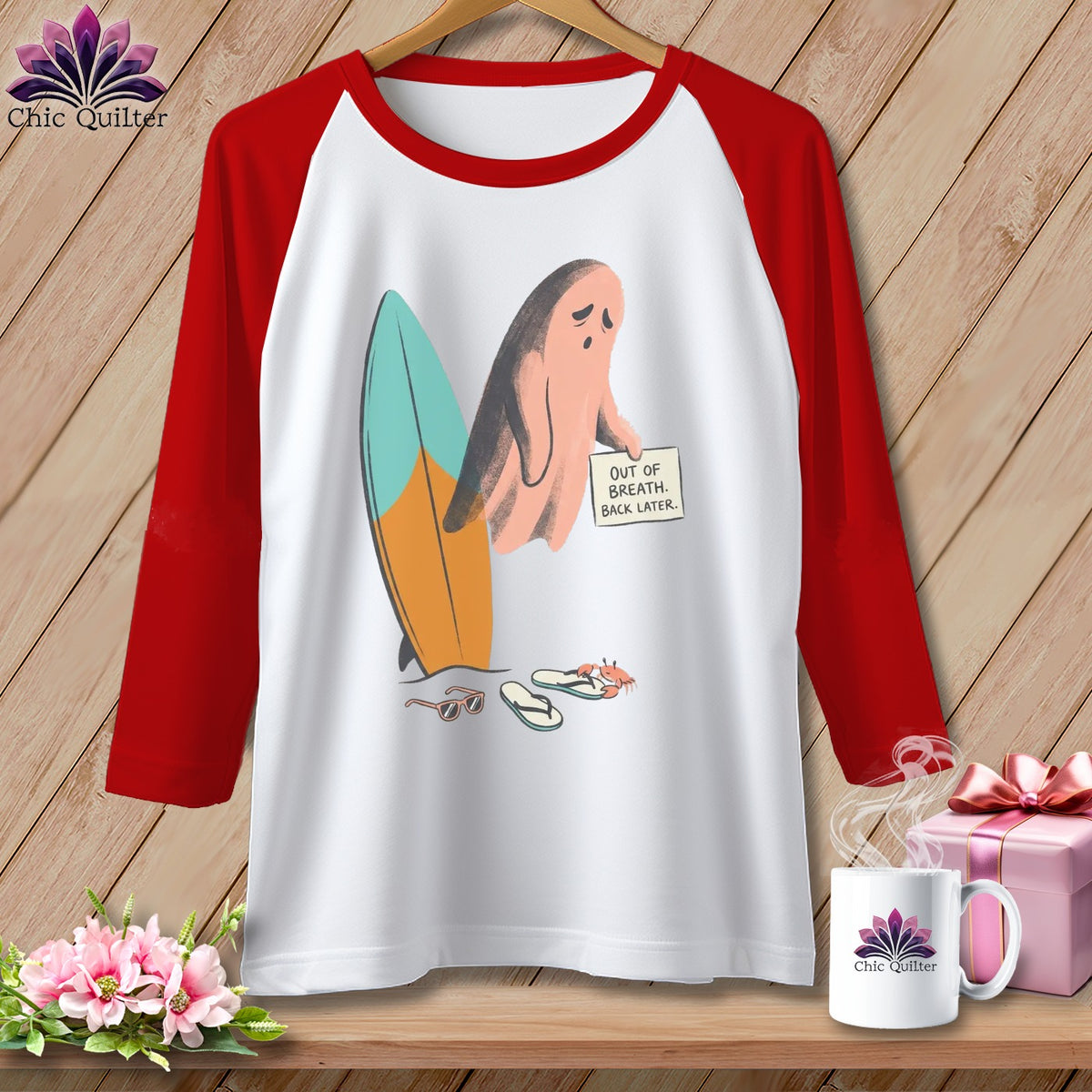Baseball tee with ghost holding sign next to surfboard, sunglasses, and flip-flops.