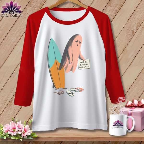 Baseball tee with ghost holding sign next to surfboard, sunglasses, and flip-flops.