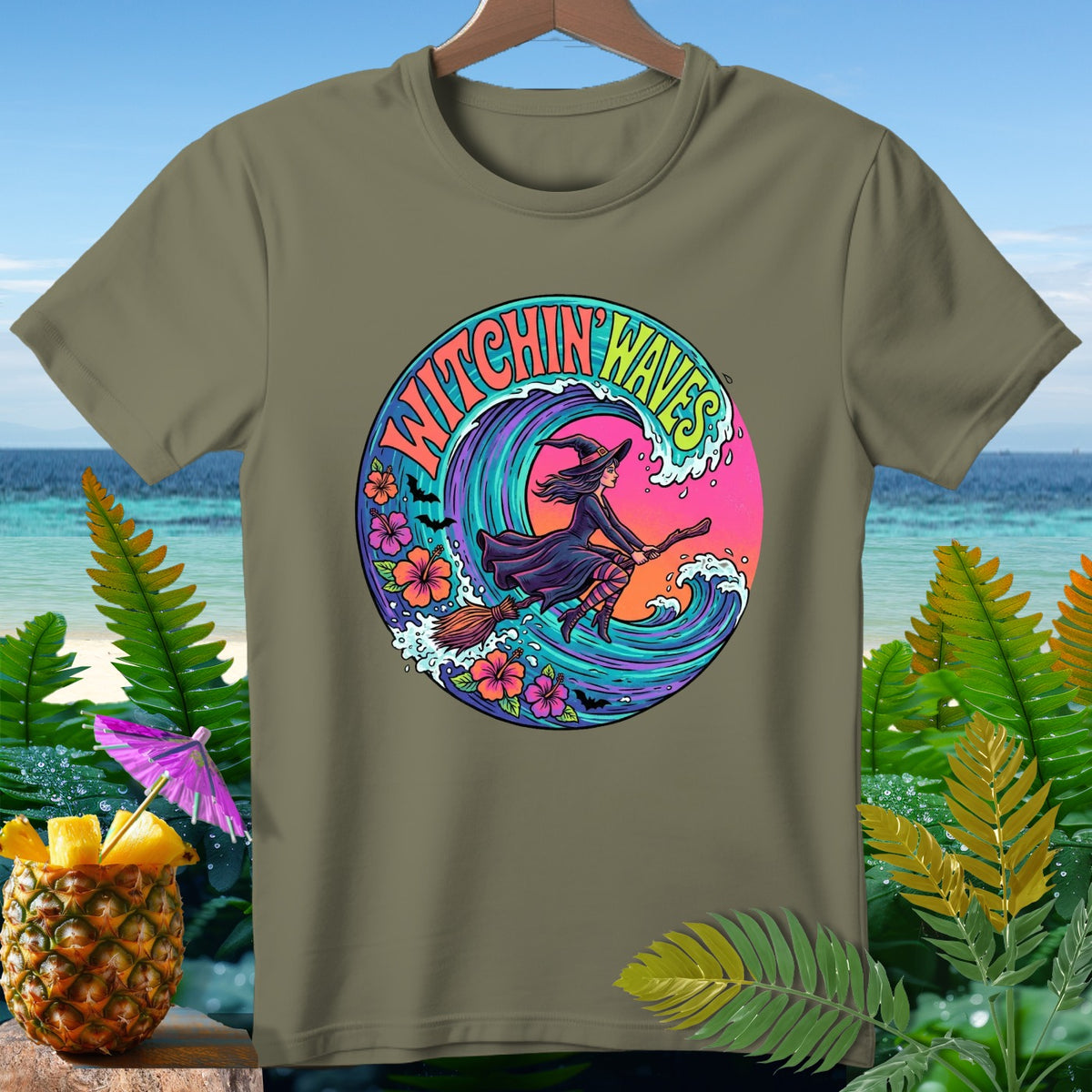 Olive green t-shirt with circular graphic of witch flying on broom over colorful wave and flowers.