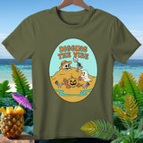 Green t-shirt with cartoon skeleton, ghost, and pumpkin digging on a beach.