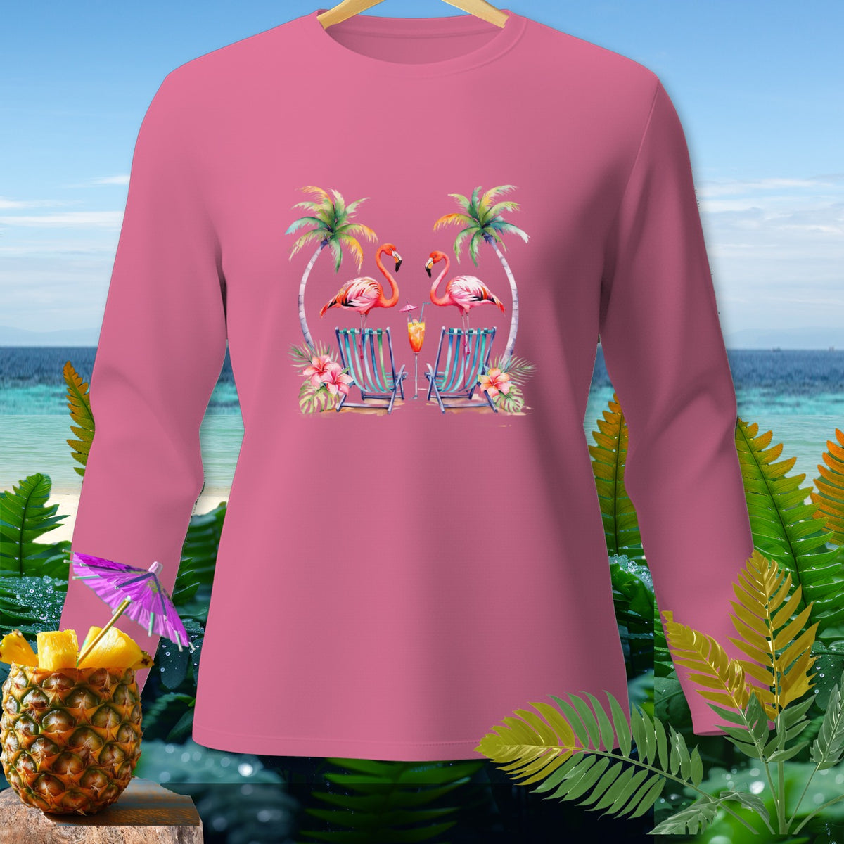 Pink long-sleeve shirt with flamingos, palm trees, and beach chairs graphic.