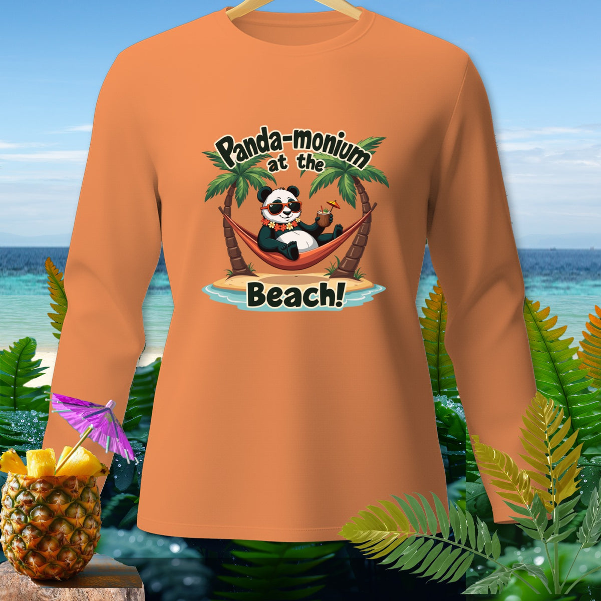 Orange long-sleeve shirt with a panda relaxing in a hammock on a beach, text "Panda-monium at the Beach!".