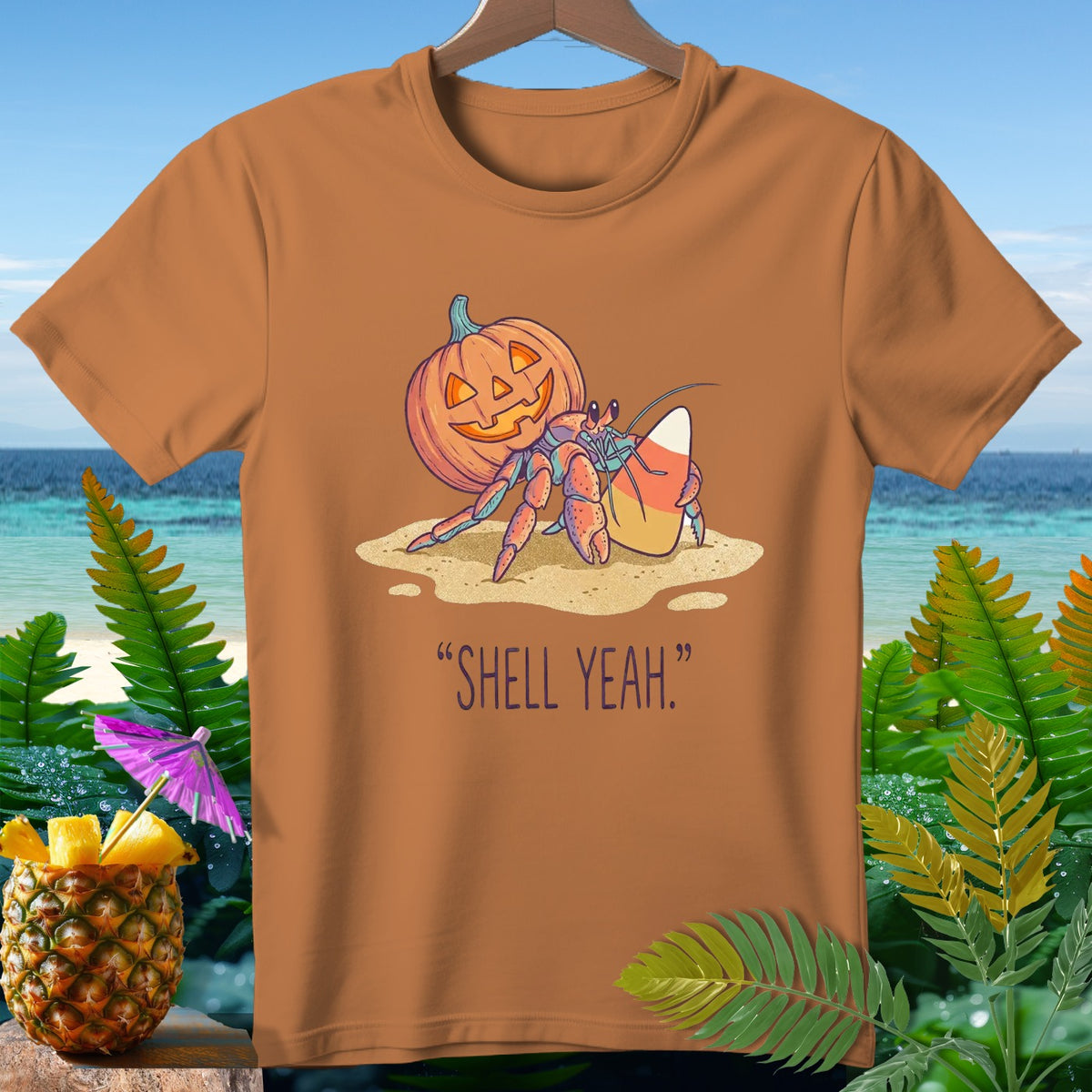 Hermit crab with pumpkin and candy corn on sand, text "SHELL YEAH."