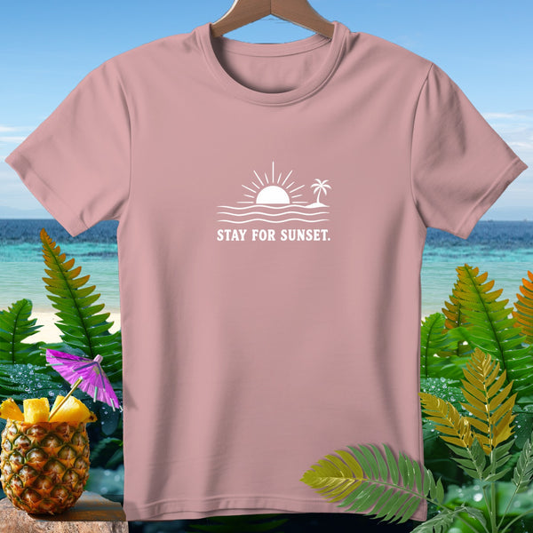 Pink t-shirt with a white graphic of a sun, waves, and a palm tree, text reads "STAY FOR SUNSET."
