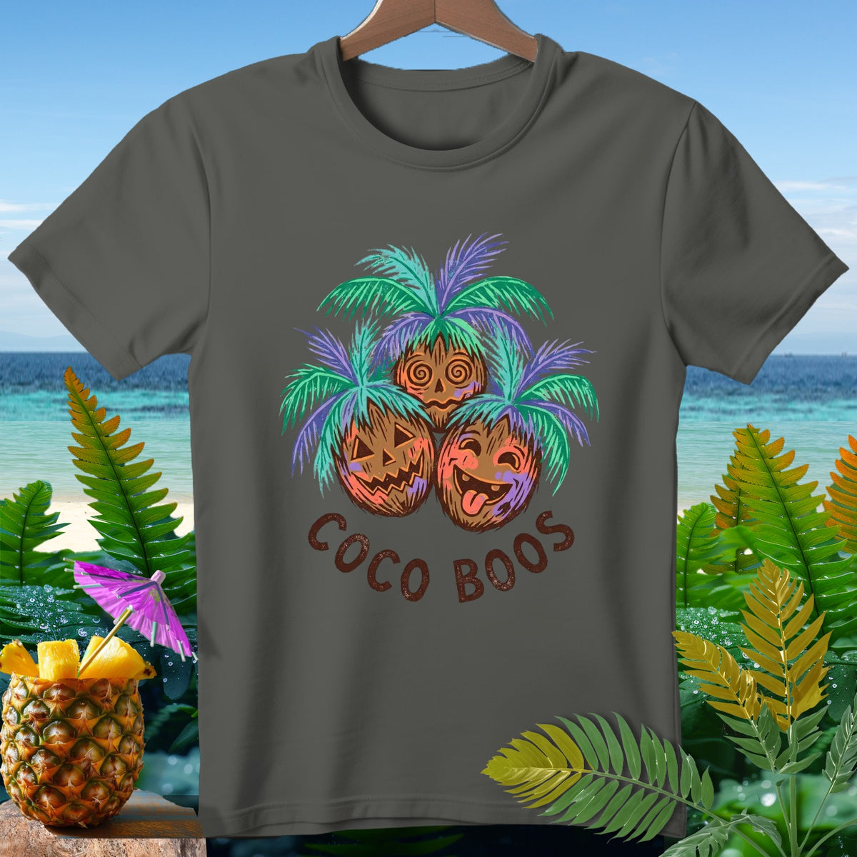 T-shirt with three carved coconut faces and palm fronds, saying "Coco Boos".