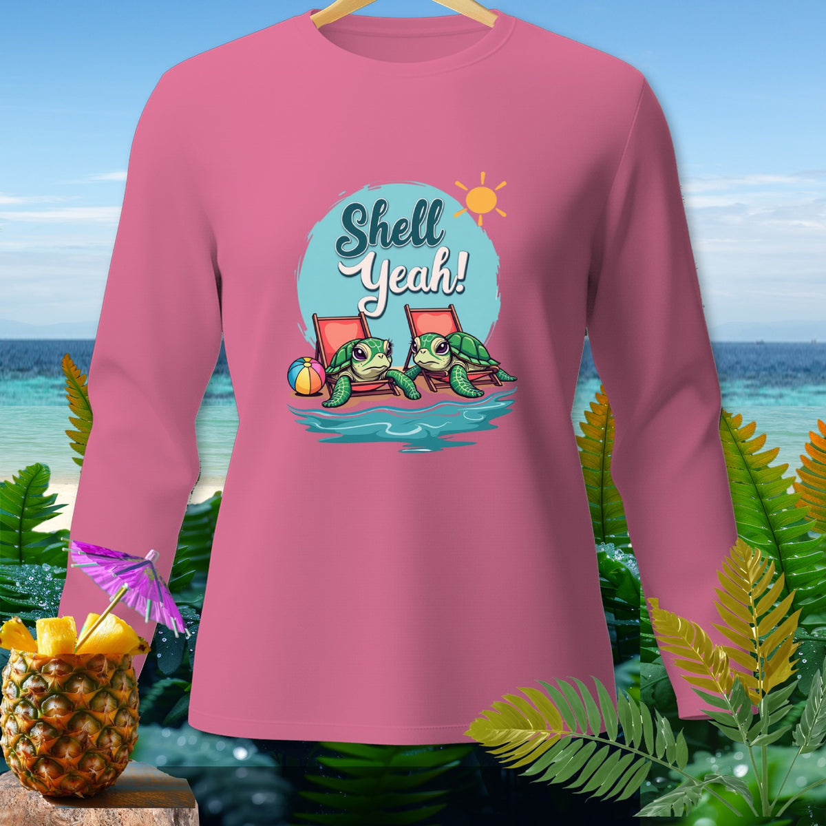 Pink long-sleeved shirt with cartoon turtles on beach chairs saying "Shell Yeah!".