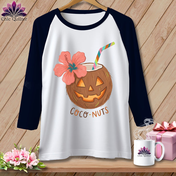 White raglan shirt with jack-o'-lantern coconut, hibiscus flower, and "Coco-Nuts" text.