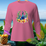 Pink long-sleeve shirt with peacock and fruit graphic, against a tropical beach backdrop.