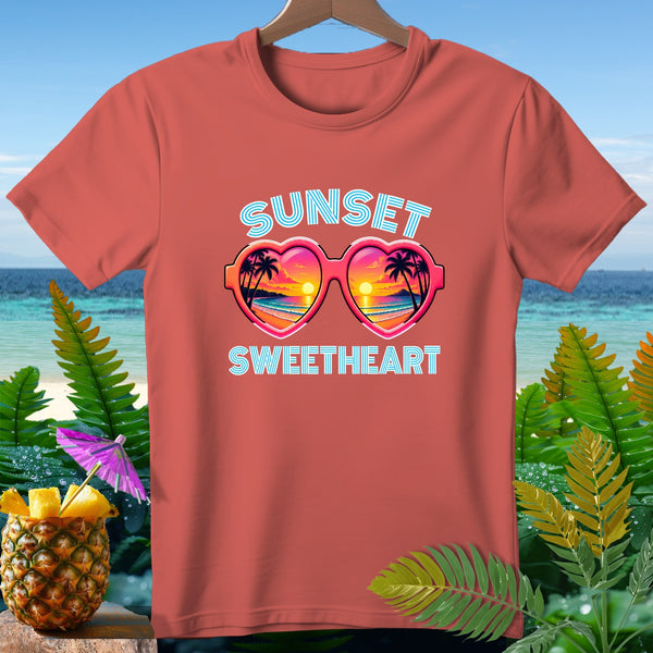 Coral t-shirt with "Sunset Sweetheart" text and heart-shaped sunglasses reflecting a sunset.