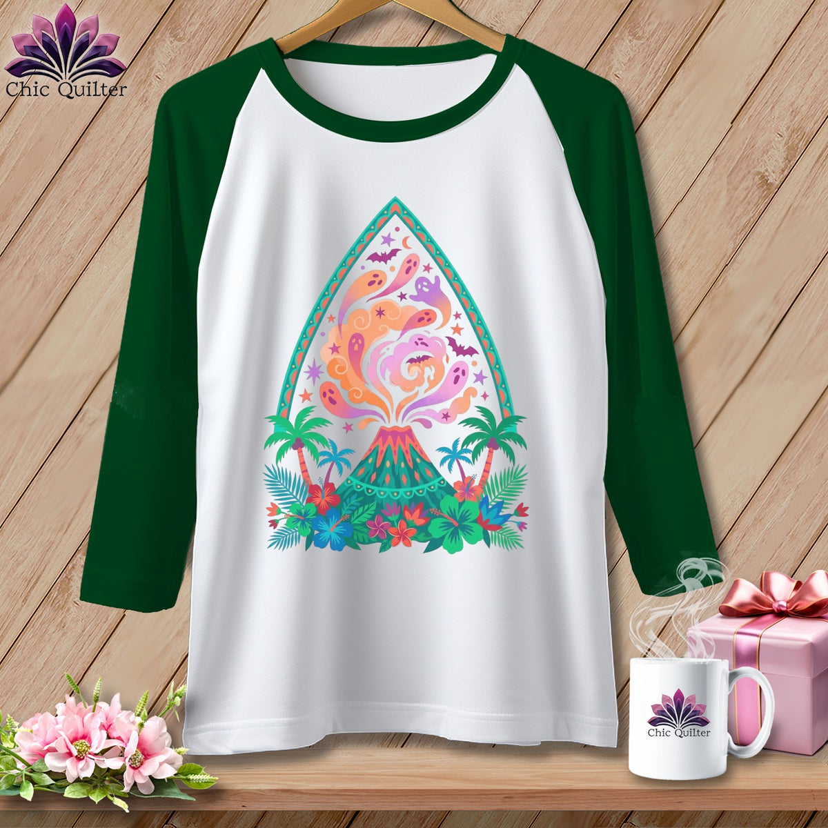 White raglan shirt with a colorful volcano graphic featuring ghosts and tropical plants.