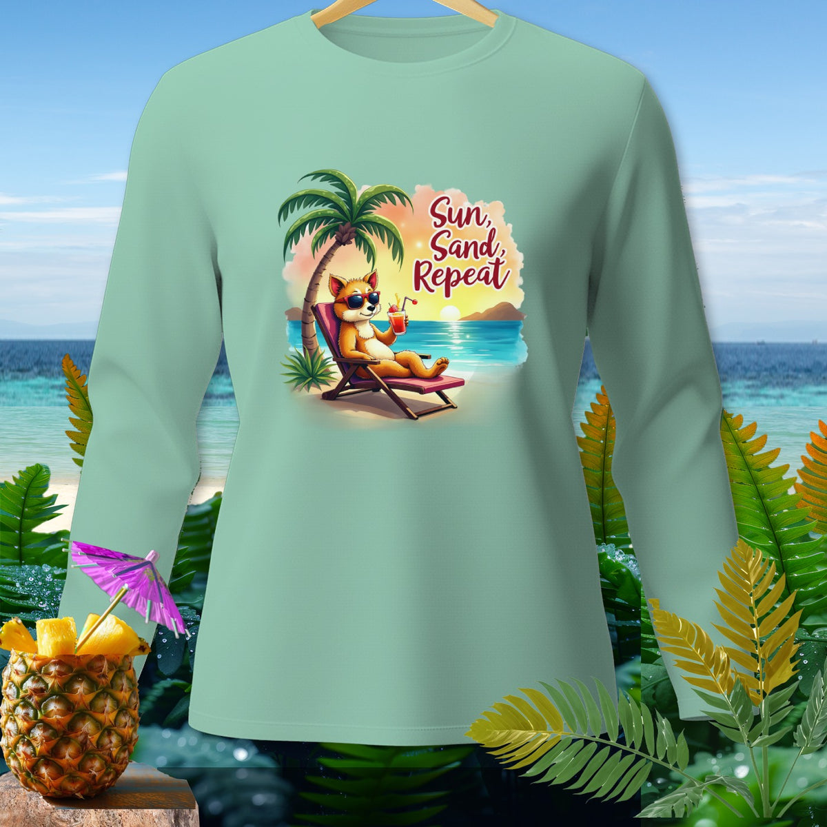 Light green long-sleeve shirt with a cartoon fox on a beach chair, text "Sun, Sand, Repeat".