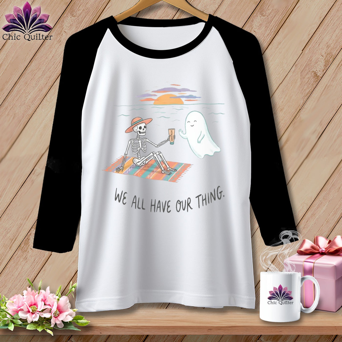 T-shirt with skeleton and ghost on beach, text "WE ALL HAVE OUR THING."