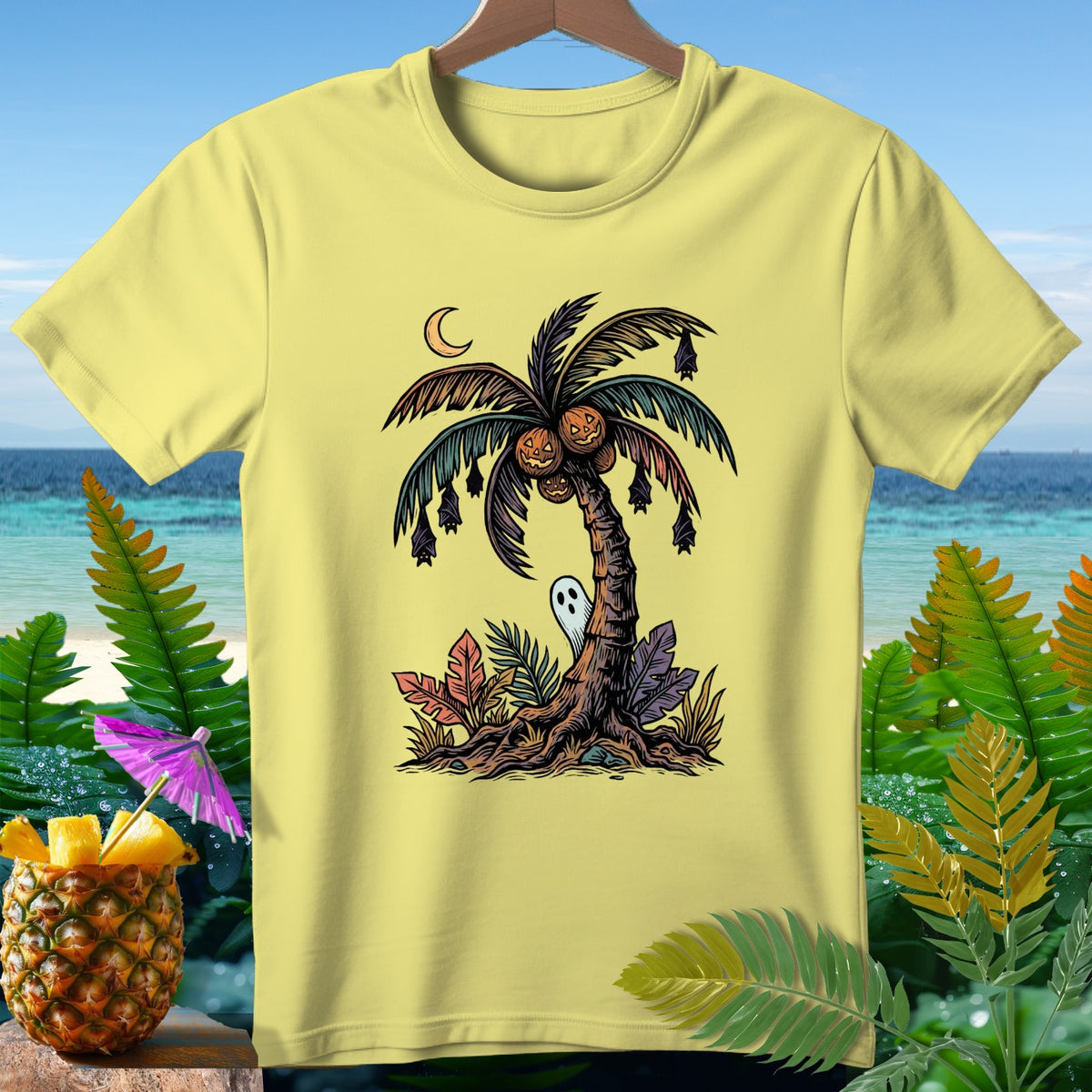 Yellow t-shirt with a Halloween palm tree design featuring pumpkins, bats, and a ghost.