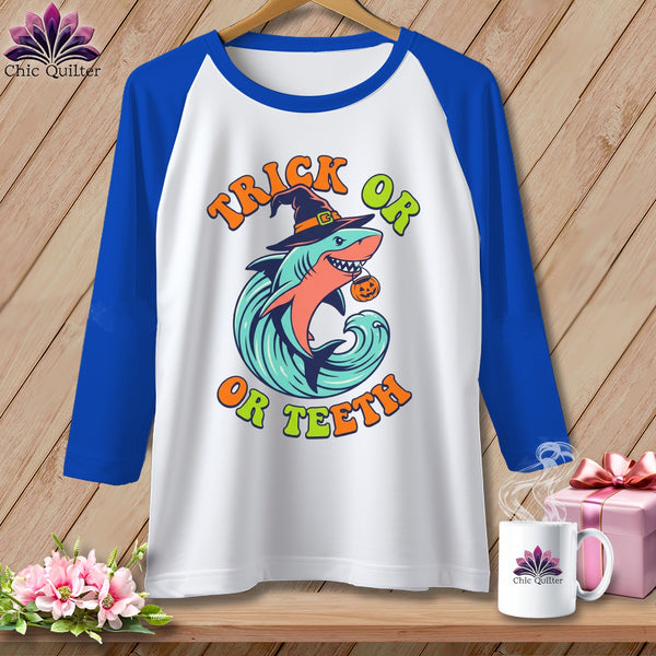 White t-shirt with blue sleeves featuring a shark in a witch hat with "Trick or Teeth" text.
