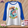 White t-shirt with blue sleeves featuring a shark in a witch hat with "Trick or Teeth" text.