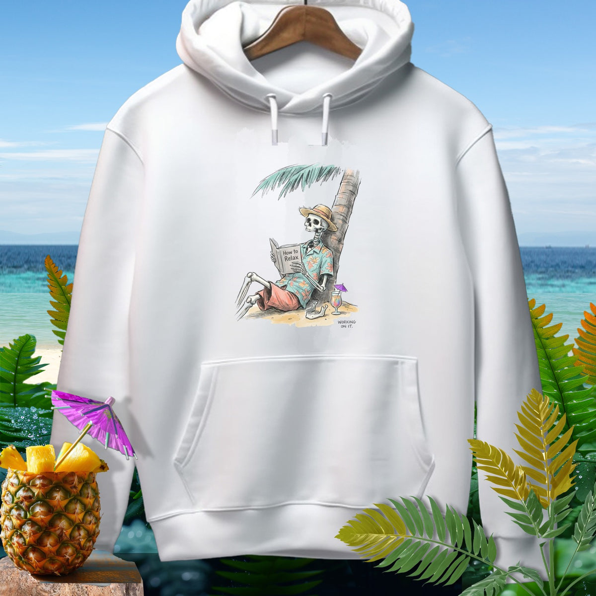 White hoodie with skeleton reading "How to Relax" on a beach.