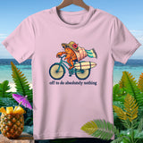Pink t-shirt with a cartoon crab riding a bicycle and the text 