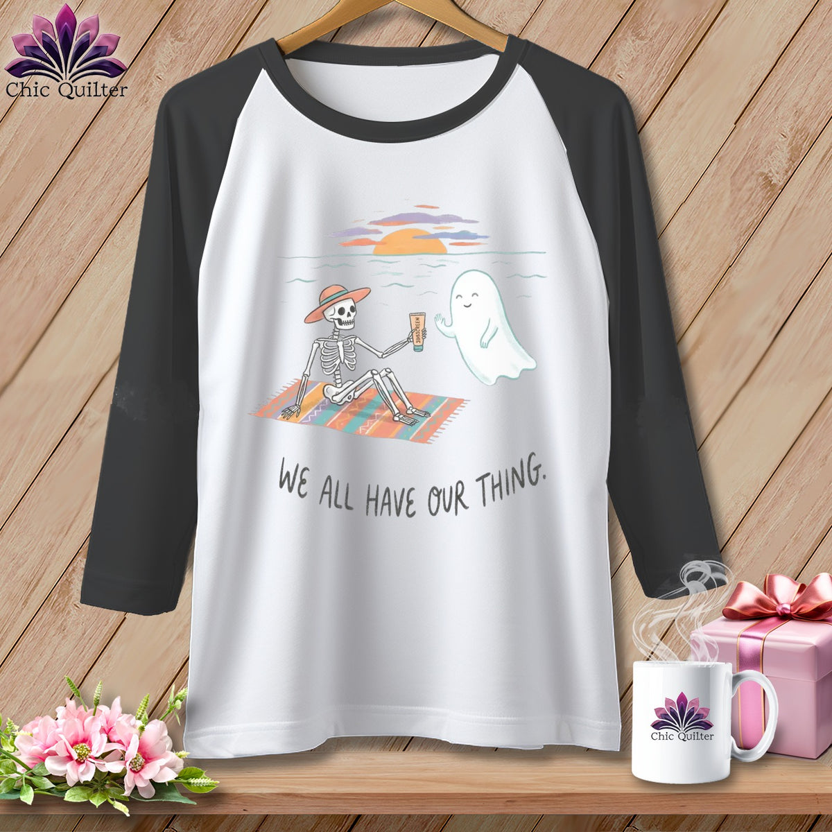Skeleton and ghost on beach blanket with sunscreen, text "We All Have Our Thing".