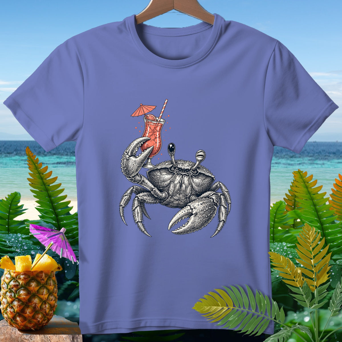 T-shirt graphic of a crab holding a tropical drink with a pineapple and beach background.