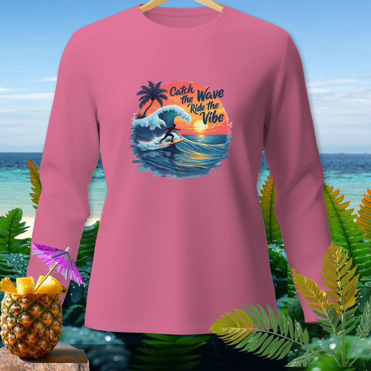 Pink long-sleeved shirt with a graphic of a surfer, waves, palm tree, and sunset.