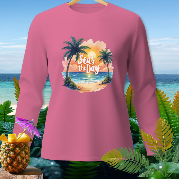 Pink long-sleeve shirt with "Seas the Day" beach graphic and tropical background.