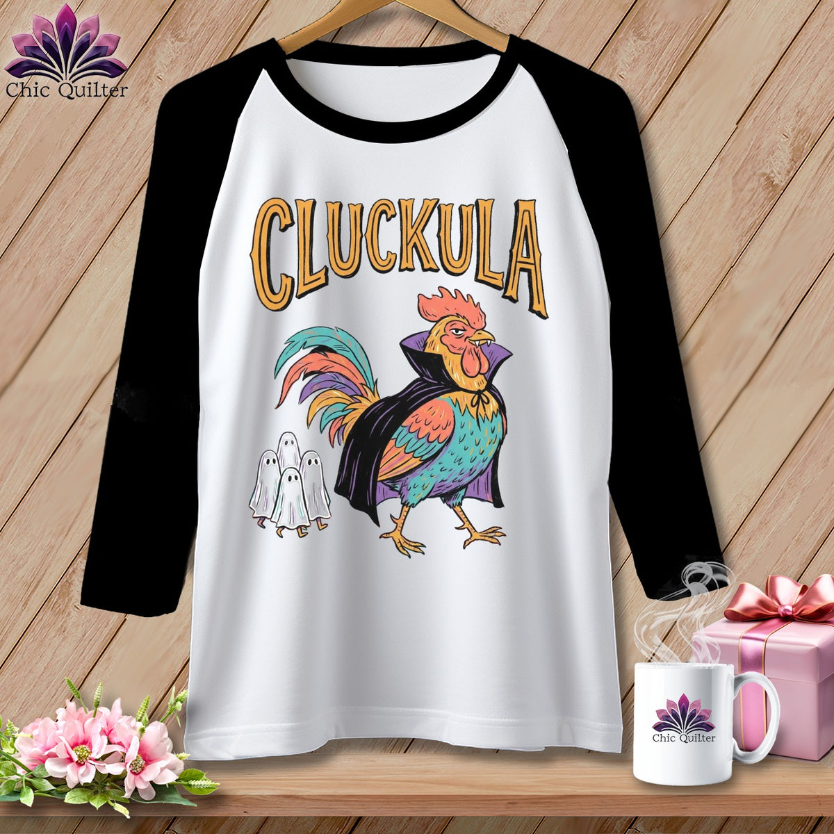 Raglan t-shirt with a colorful rooster in a cape and ghosts, text reads "CLUCKULA".
