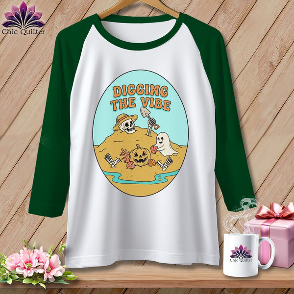 Raglan t-shirt with skeleton, pumpkin, and ghost graphic that reads "Digging The Vibe."