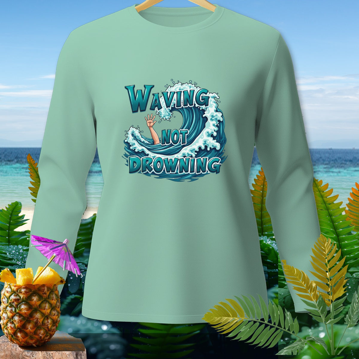 Mint green long-sleeve shirt with "Waving Not Drowning" text graphic.